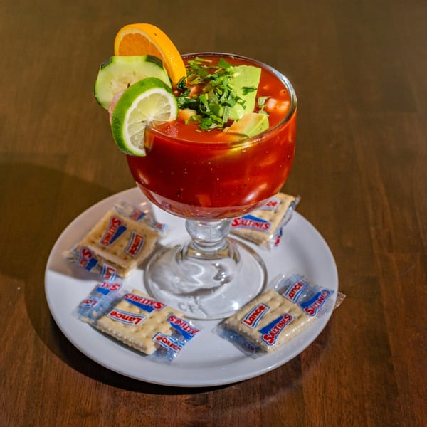 Chuyita's Mexican Restaurant and Bar's shrimp cocktail in a goblet with lime, orange, cucumber, and saltines.